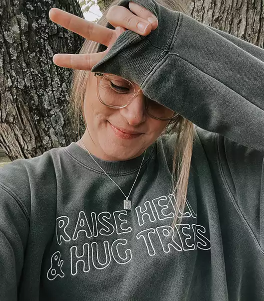 blonde woman wearing sweatshirt with white text